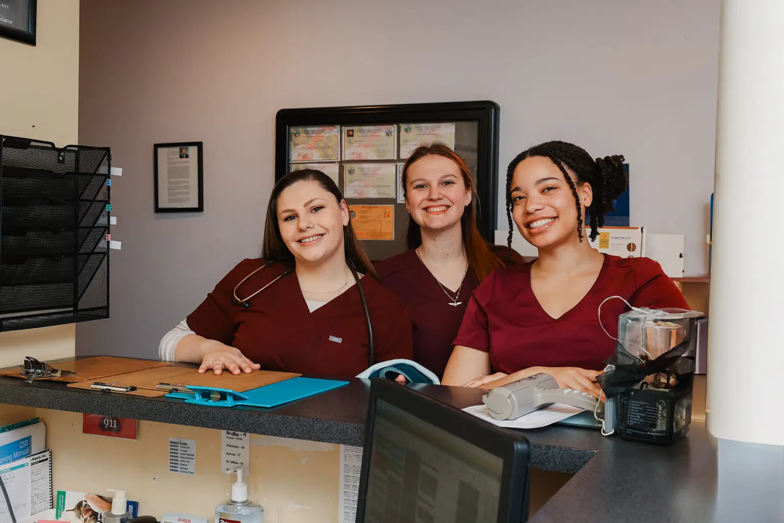 Veterinary team members smiling at the front desk at Arnold Veterinary Hospital in Arnold, MD
